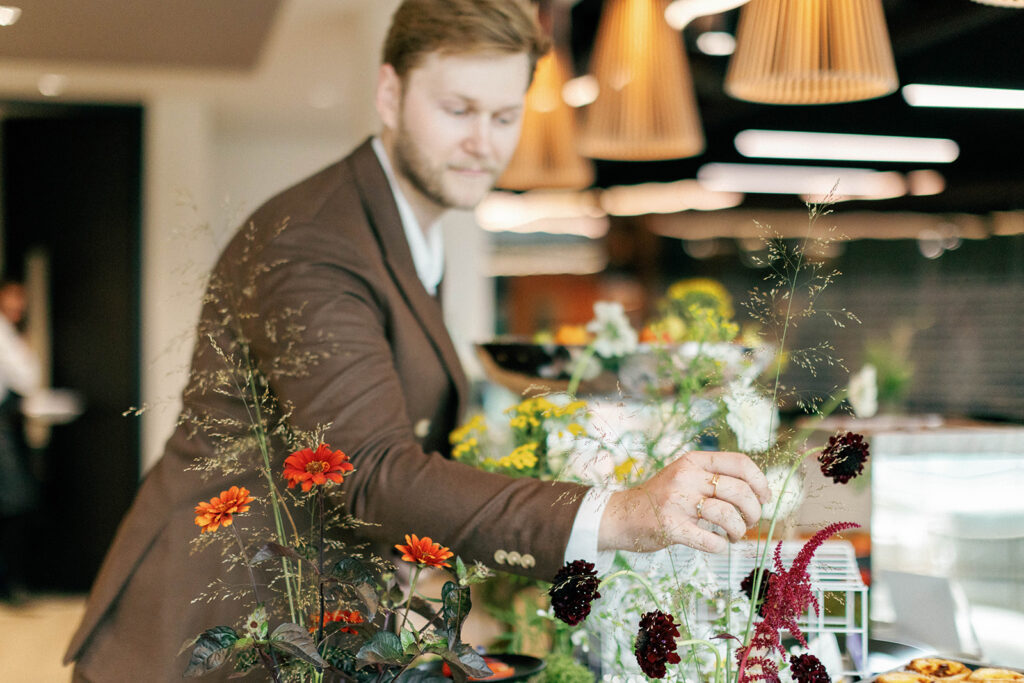 Founder James Green perfecting the floral arrangements on a food station display.