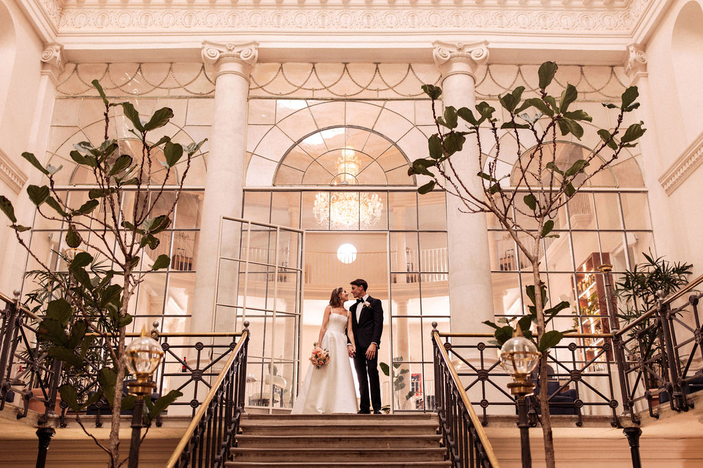 A romantic shot of a couple on the ornate staircase at Old Sessions House, capturing a moment of intimacy.