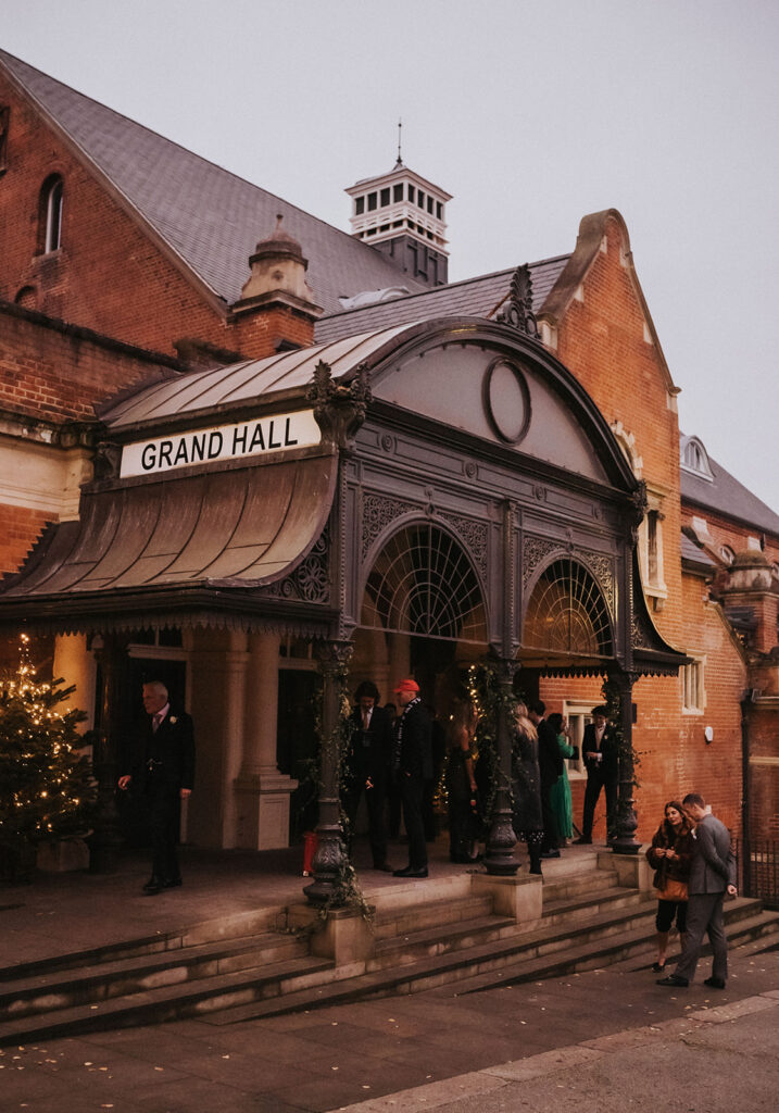 The iconic exterior of Battersea Arts Centre, beautifully illuminated as the venue for Clem and Finn’s Christmas wedding celebration.