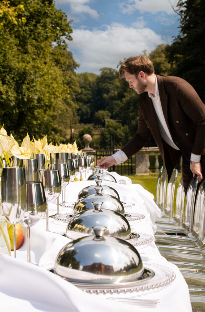 Wedding planner adjusting table settings, demonstrating meticulous attention to detail.