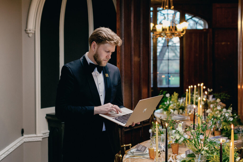 James Green holding a clipboard and phone, multitasking seamlessly during a busy wedding day.