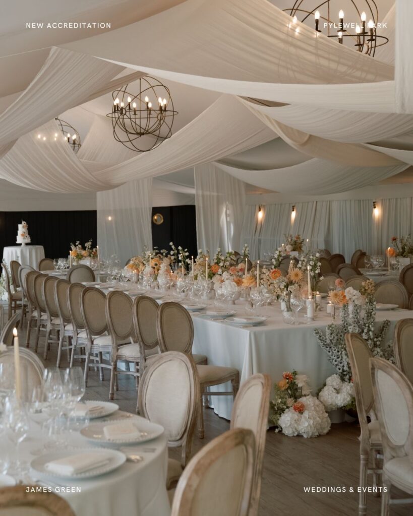 Sophisticated Pylewell Park wedding reception setup inside a draped marquee with round and long tables, soft florals, and candlelight.